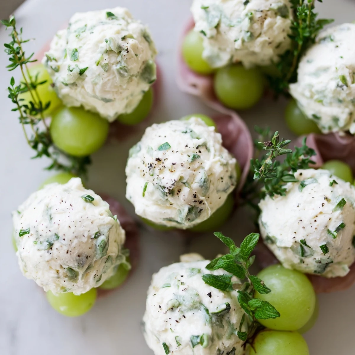 Vibrant image of a Mistletoe Kissing Ball, showcasing grapes, cheese balls, and aromatic herbs for holidays.
