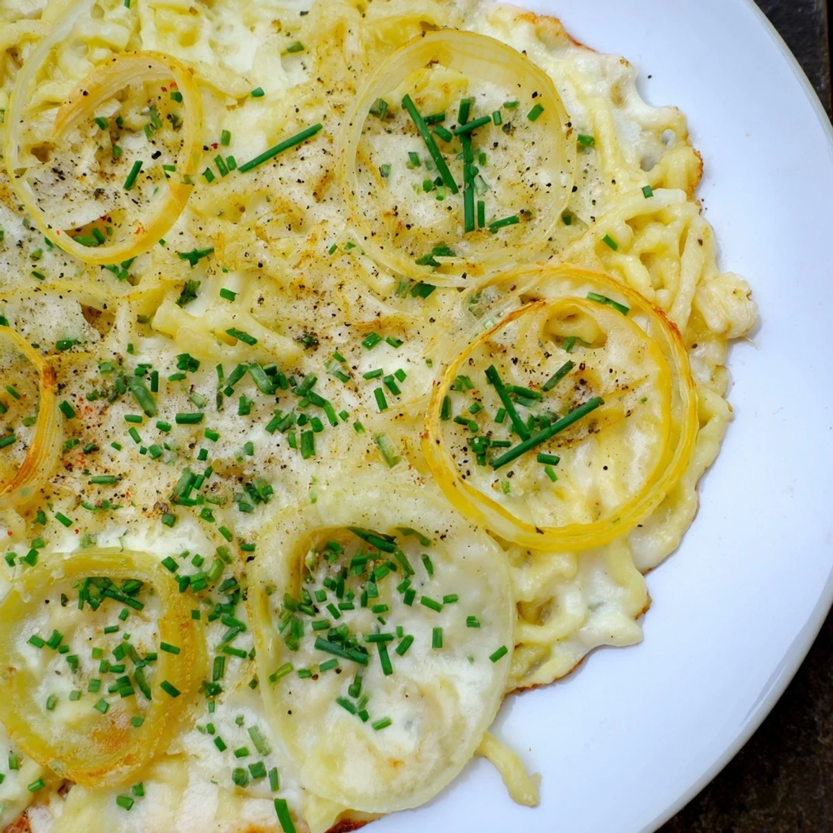 Generously portioned Käsespätzle, topped with fresh herbs, ready for a comforting German meal.