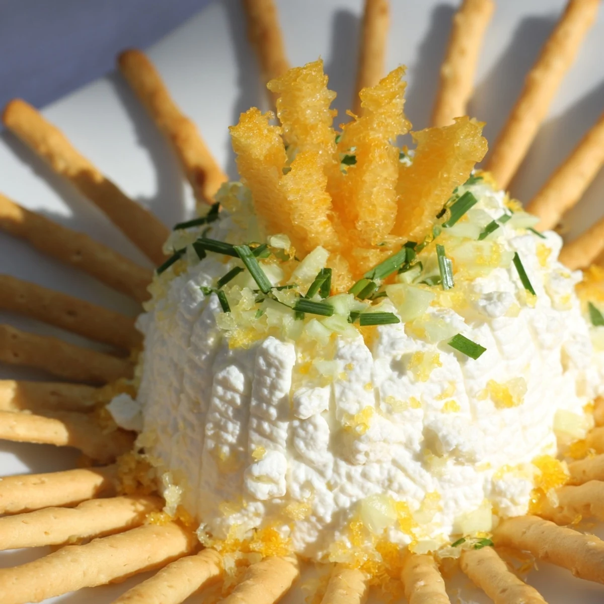 A visually stunning Tuscan Sunburst appetizer: yellow peppers arranged around creamy goat cheese.