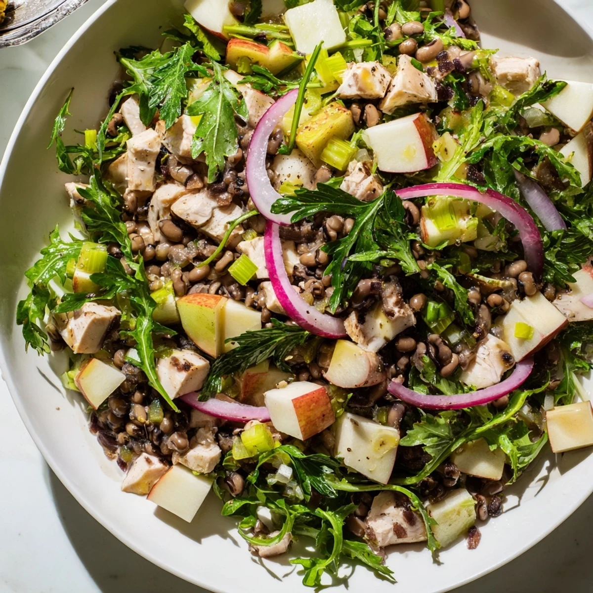 Chicken and Apple New Years Luck Salad: a colorful bowl with shredded chicken, apple chunks, and black-eyed peas.