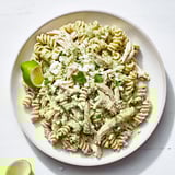 Ein großer Teller mit Cilantro Lime Chicken Pasta, wo rotini-Nudeln und zarte Hühnerfleischstücke in einer cremigen, grünen Joghurt-Sauce liegen.