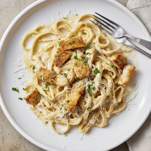 Cajun Chicken Alfredo mit garnierter Petersilie auf Teller, cremige Soße ummantelt Nudeln