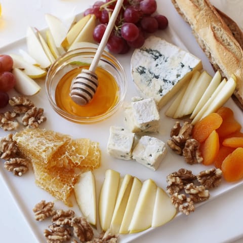 This stunning honeycomb, honey & cheese board showcases cheeses, fruits, nuts, and floral honey for appetizers.