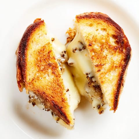 Eine aromatische Truffle Grilled Cheese Sandwich mit würzigem Gruyère auf knusprigen Brotscheiben.  