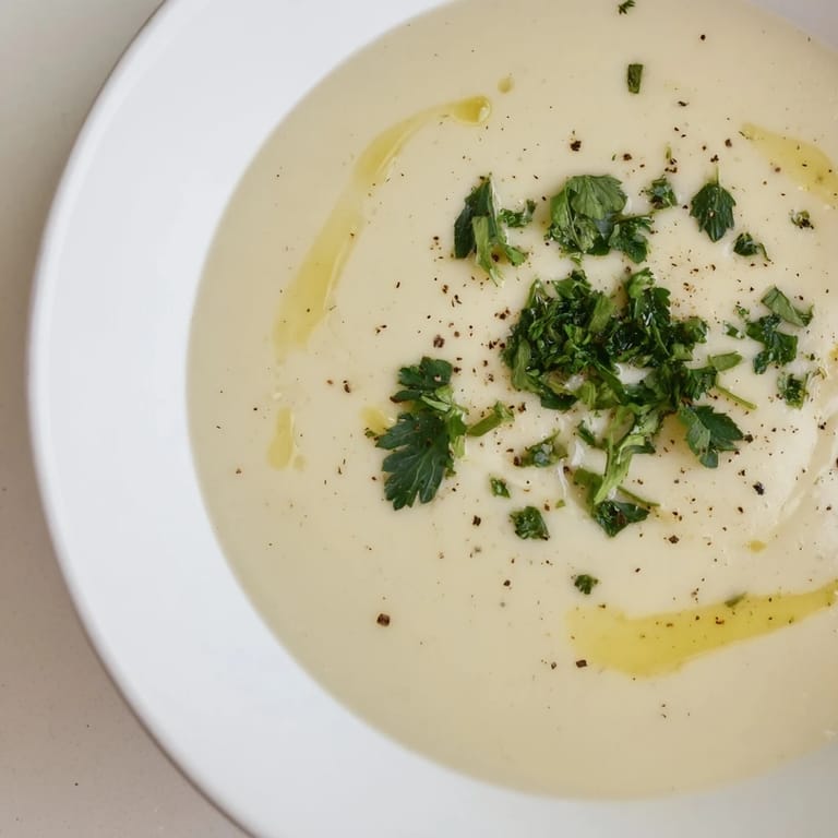 A close-up of a warm bowl of creamy garlic potato soup, perfect for a comforting weeknight meal.