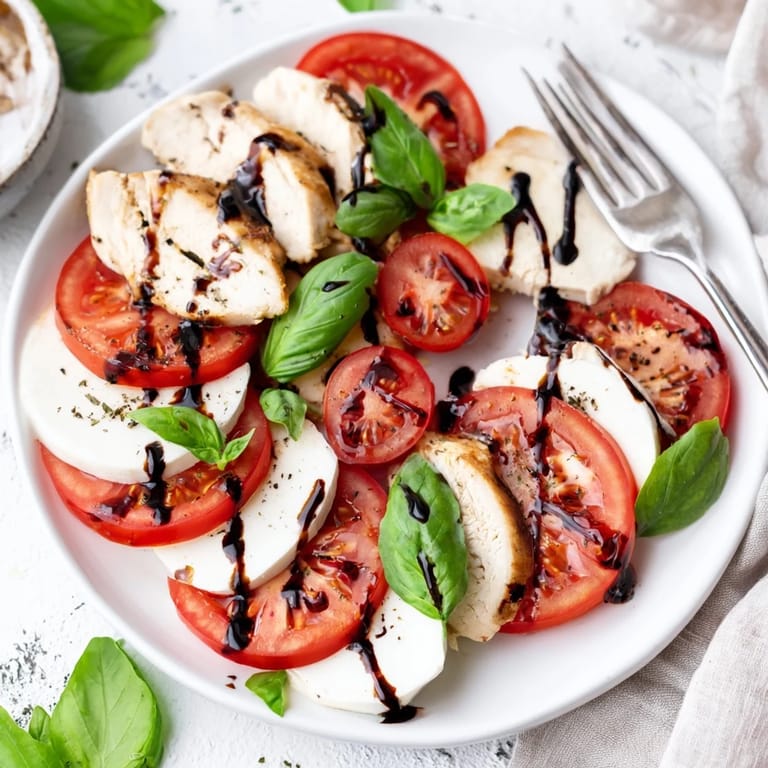 Grilled chicken Caprese salad with fresh basil and balsamic drizzle, ready for lunch.