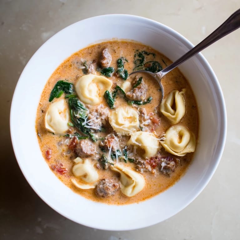 Köstliche Tuscan Tortellini Soup mit Spinat, Tomaten-Sahne-Sauce und aromatischen italienischen Gewürzen serviert.