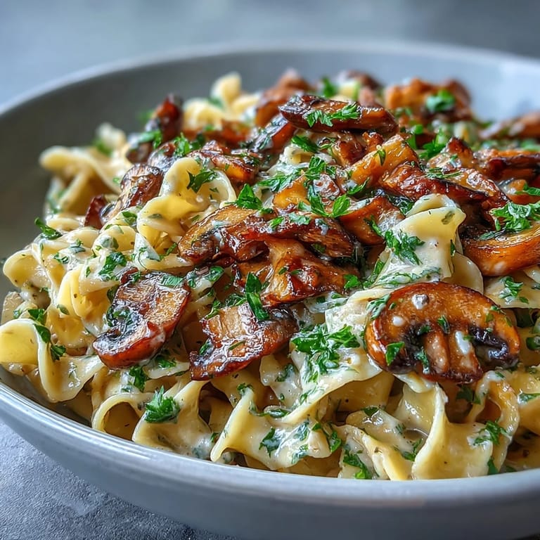 Creamy Mushroom Stroganoff plated beside a glass of white wine for an easy weeknight vegetarian dinner.