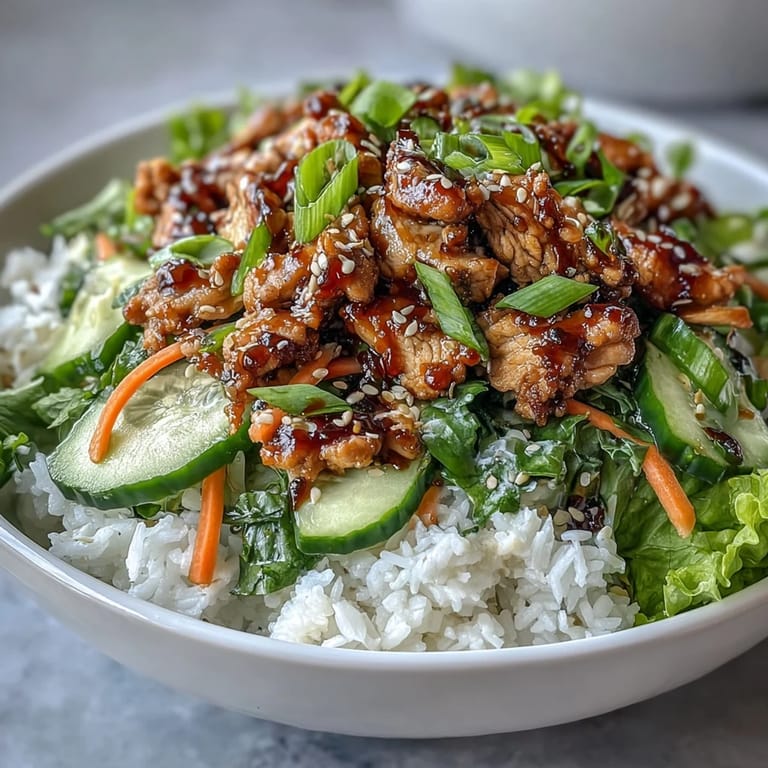 Fragrant sesame turkey, cucumber ribbons, and julienned carrots piled over rice for a fresh, vibrant meal.